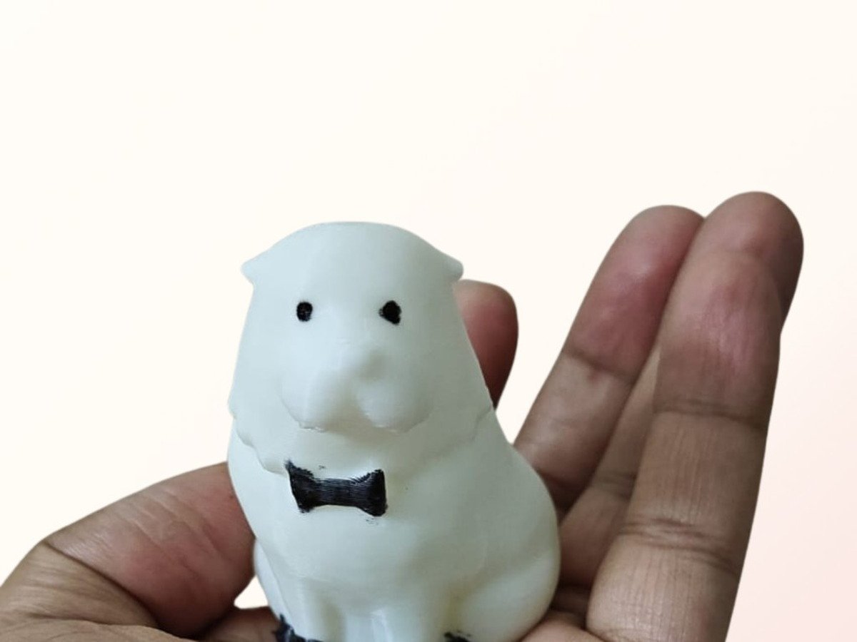 White 3D printed Bond the Dog figurine from Spy x Family held in a hand against a cream background